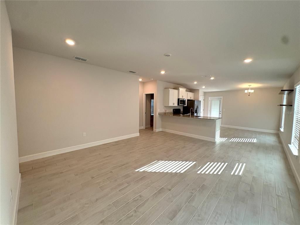 Empty room, Interior, Kitchen, Recessed Lighting, Stainless Steel Appliances, Wood Texture Flooring