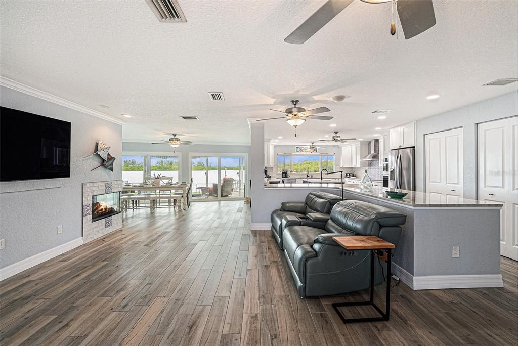 Dining room, Fireplace, Interior, Kitchen, Living room, Recessed Lighting, Stainless Steel Appliances, Wood Texture Flooring