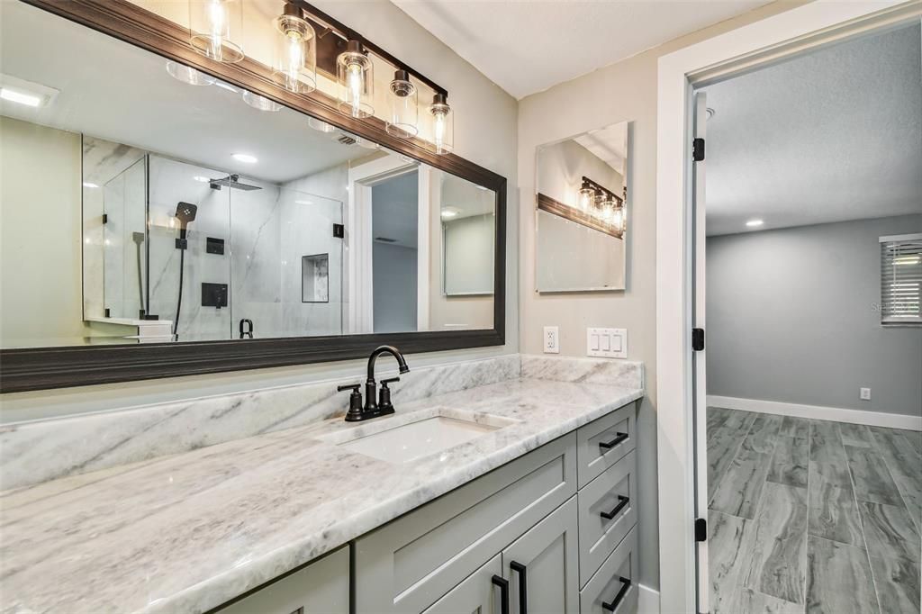 Bathroom, Dual Sink Vanities, Glass Shower, Interior, Marble, Marble Walls, Recessed Lighting, Wood Texture Flooring