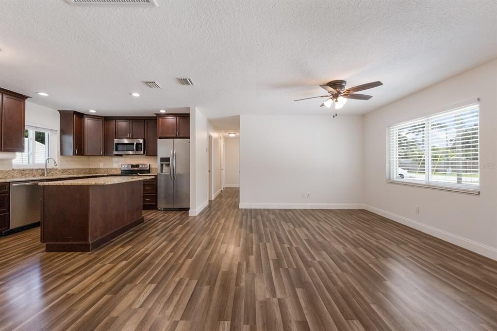 Empty room, Interior, Kitchen, Recessed Lighting, Stainless Steel Appliances, Wood Texture Flooring