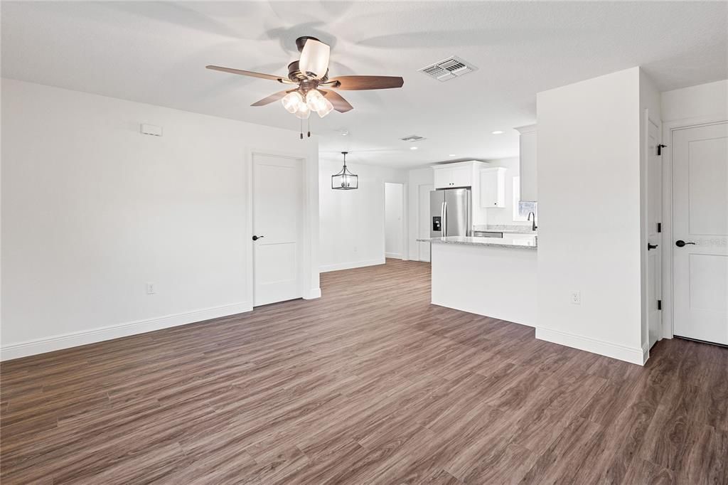 Empty room, Interior, Kitchen, Recessed Lighting, Stainless Steel Appliances, Wood Texture Flooring