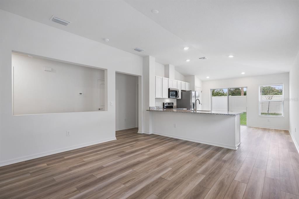 Empty room, Interior, Kitchen, Recessed Lighting, Stainless Steel Appliances, Wood Texture Flooring