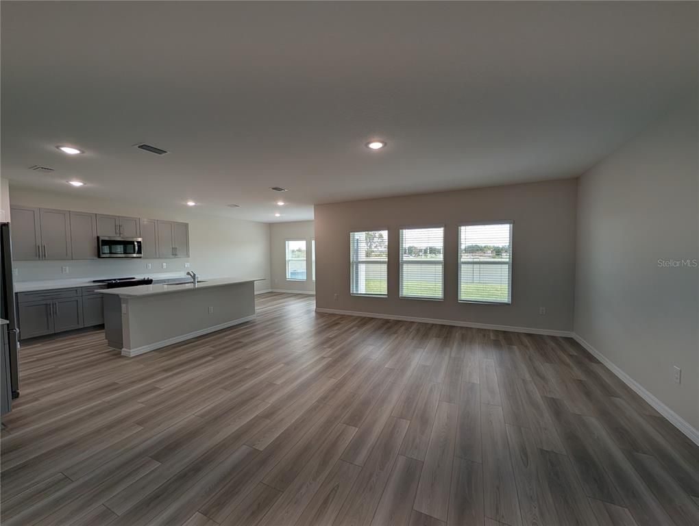Empty room, Interior, Kitchen, Recessed Lighting, Stainless Steel Appliances, Wood Texture Flooring