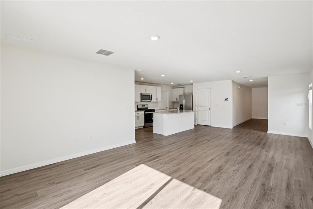 Empty room, Interior, Kitchen, Recessed Lighting, Stainless Steel Appliances, Wood Texture Flooring