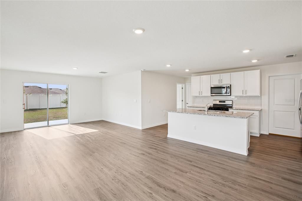 Empty room, Interior, Kitchen, Recessed Lighting, Stainless Steel Appliances, Wood Texture Flooring