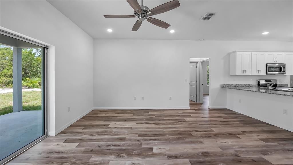 Empty room, Interior, Kitchen, Recessed Lighting, Stainless Steel Appliances, Wood Texture Flooring