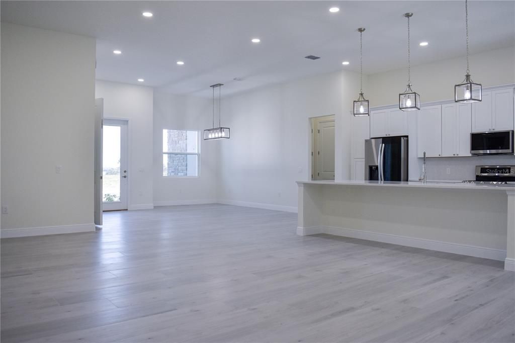 Empty room, Interior, Kitchen, Pendant Lights, Recessed Lighting, Stainless Steel Appliances, Wood Texture Flooring