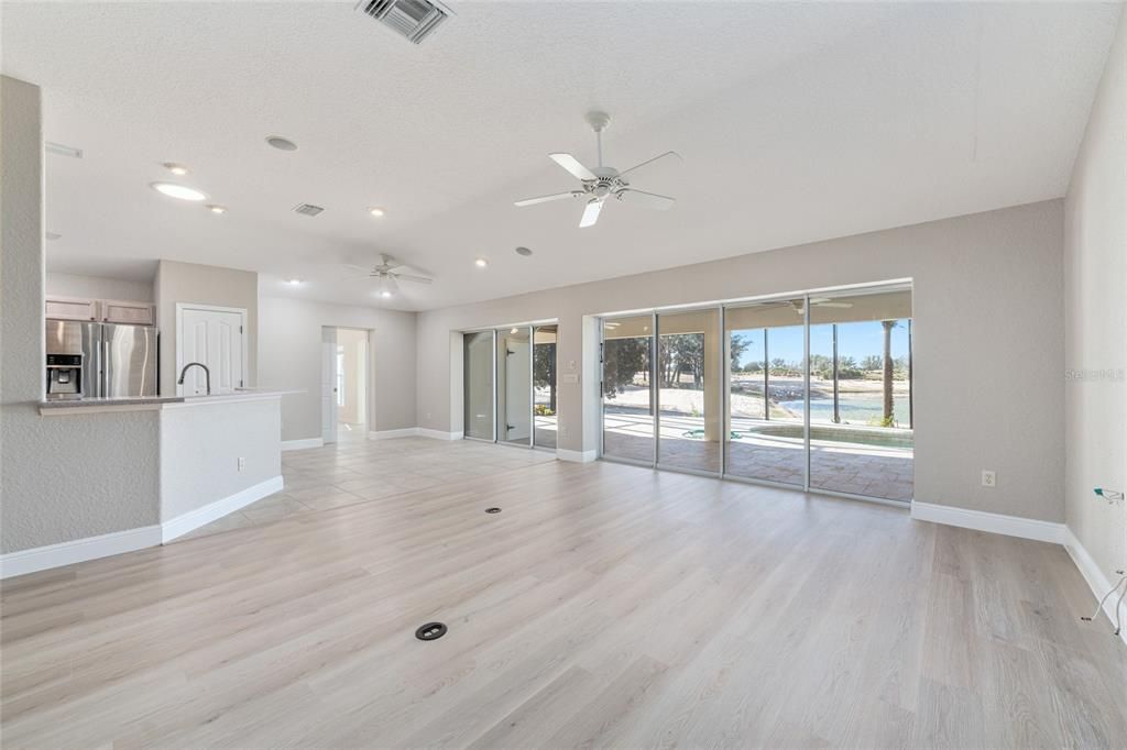 Empty room, Interior, Kitchen, Recessed Lighting, Stainless Steel Appliances, Wood Texture Flooring