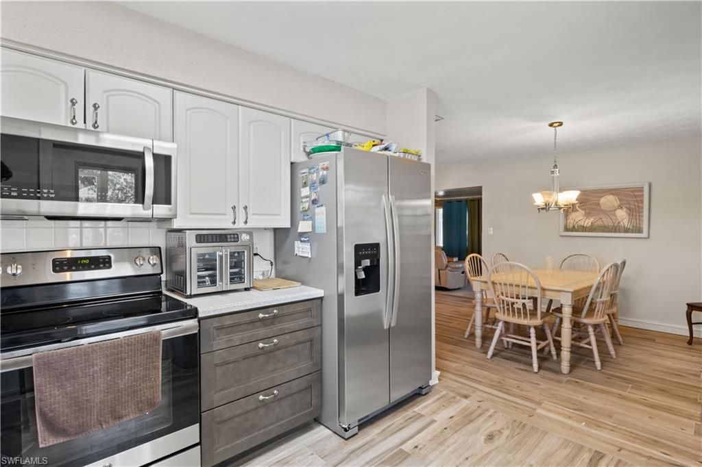 Chandelier, Dining room, Interior, Kitchen, Pendant Lights, Stainless Steel Appliances, Wood Texture Flooring