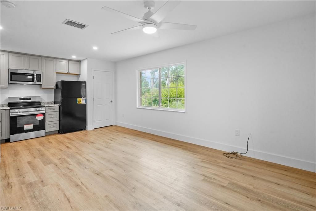 Empty room, Interior, Kitchen, Recessed Lighting, Stainless Steel Appliances, Wood Texture Flooring