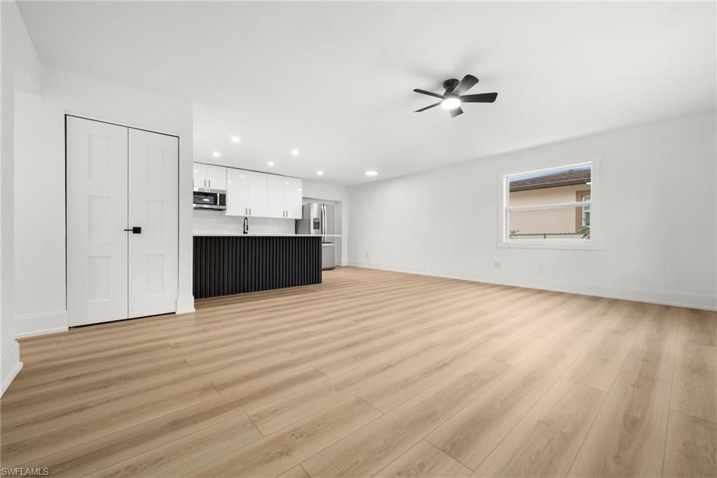 Empty room, Interior, Kitchen, Recessed Lighting, Stainless Steel Appliances, Wood Texture Flooring