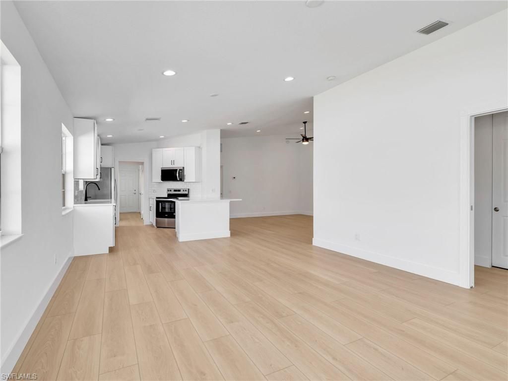 Empty room, Interior, Kitchen, Recessed Lighting, Stainless Steel Appliances, Wood Texture Flooring