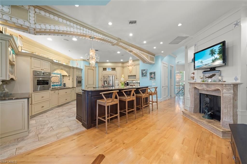 Chandelier, Fireplace, Interior, Kitchen, Recessed Lighting, Stainless Steel Appliances, Wood Texture Flooring