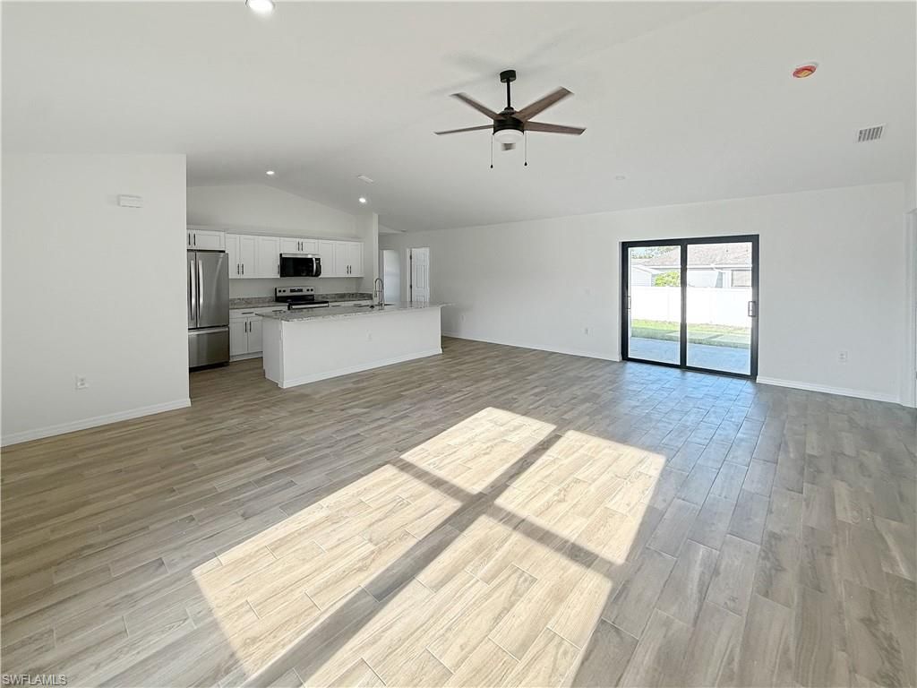 Empty room, Interior, Kitchen, Recessed Lighting, Stainless Steel Appliances, Wood Texture Flooring