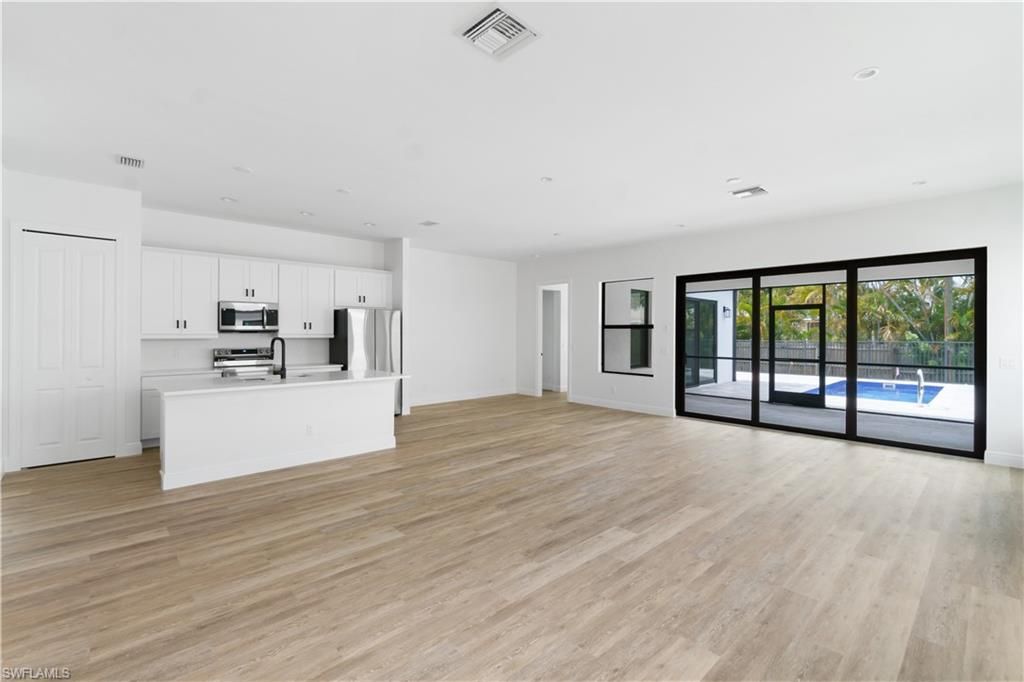 Empty room, Interior, Kitchen, Recessed Lighting, Stainless Steel Appliances, Wood Texture Flooring