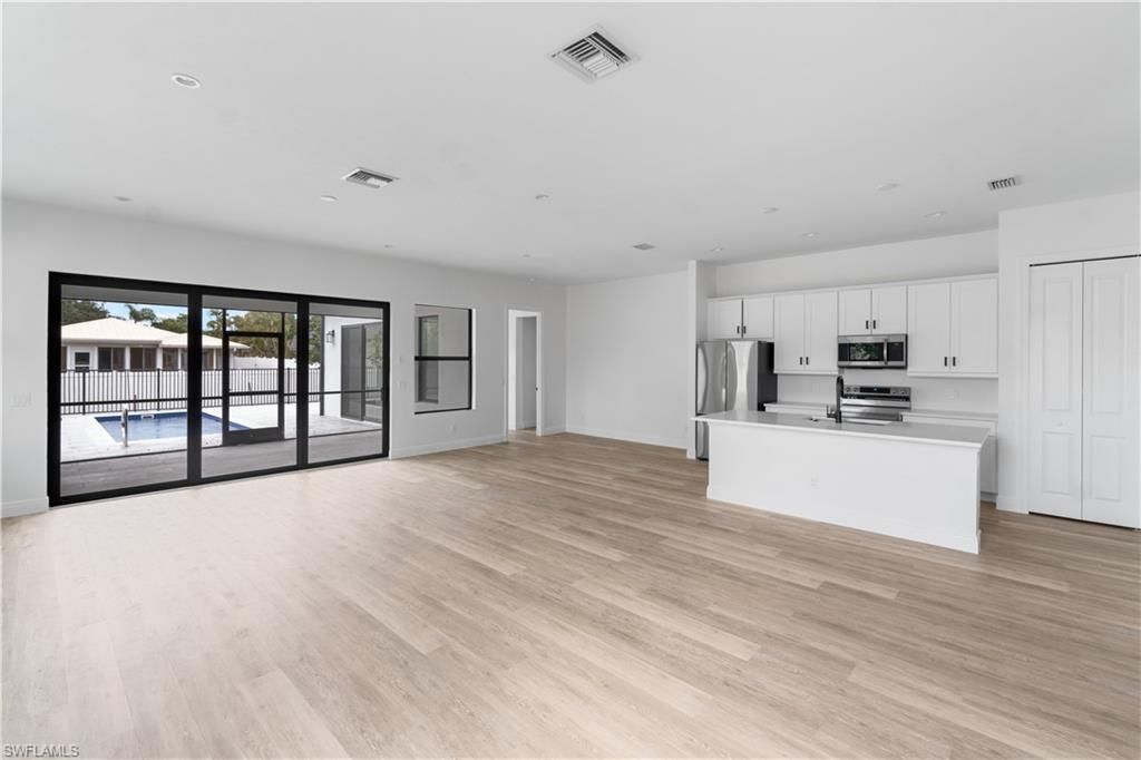 Empty room, Interior, Kitchen, Recessed Lighting, Stainless Steel Appliances, Wood Texture Flooring
