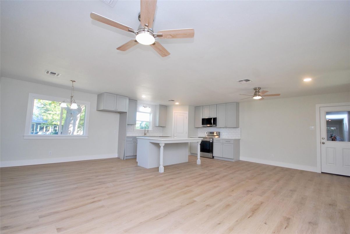 Empty room, Interior, Kitchen, Pendant Lights, Recessed Lighting, Stainless Steel Appliances, Wood Texture Flooring