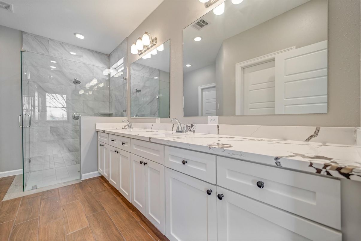Bathroom, Dual Sink Vanities, Glass Shower, Interior, Marble Walls, Recessed Lighting, Wood Texture Flooring