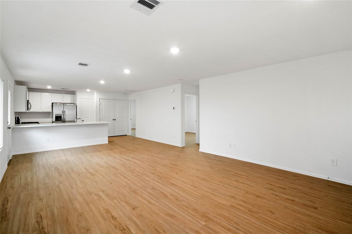 Empty room, Interior, Kitchen, Recessed Lighting, Stainless Steel Appliances, Wood Texture Flooring