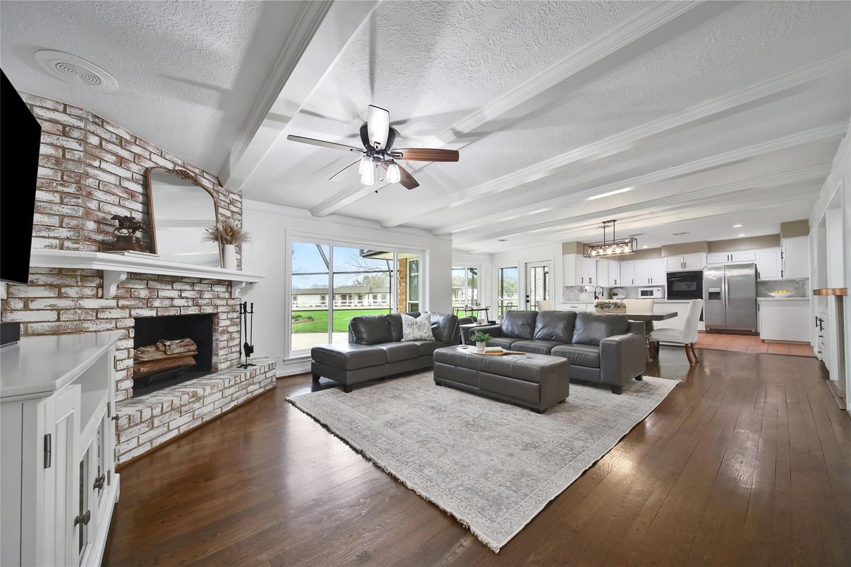Chandelier, Dining room, Fireplace, Interior, Kitchen, Living room, Pendant Lights, Stainless Steel Appliances, Stone Walls, Wood Texture Flooring