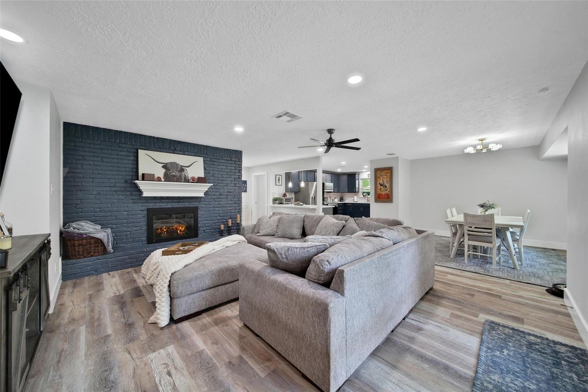 Dining room, Fireplace, Interior, Living room, Recessed Lighting, Stone Walls, Wood Texture Flooring
