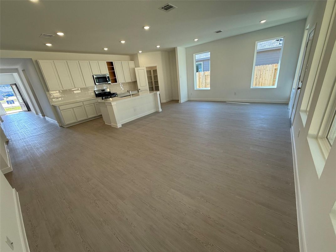 Empty room, Interior, Kitchen, Recessed Lighting, Stainless Steel Appliances, Wood Texture Flooring