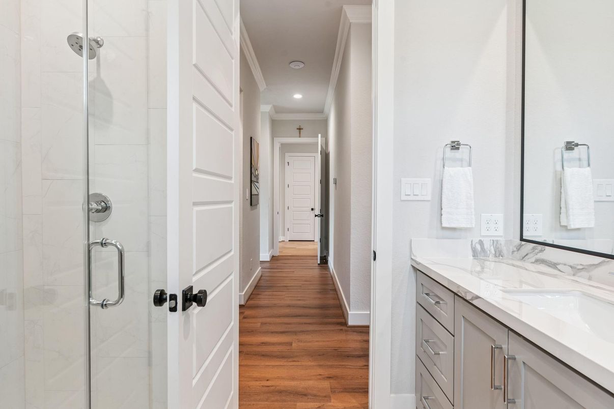 Bathroom, Dual Sink Vanities, Glass Shower, Interior, Marble Walls, Recessed Lighting, Wood Texture Flooring