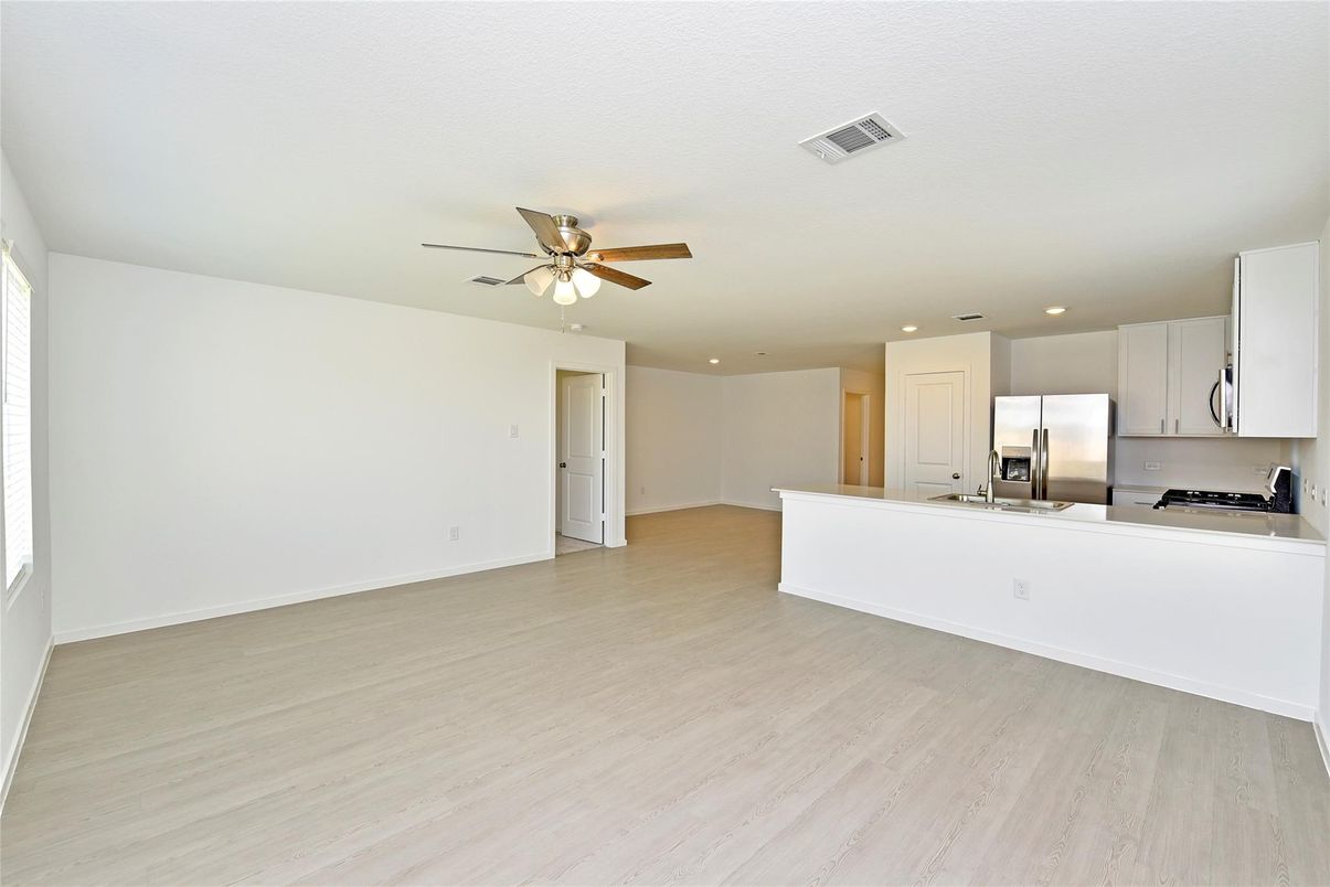 Empty room, Interior, Kitchen, Recessed Lighting, Stainless Steel Appliances, Wood Texture Flooring