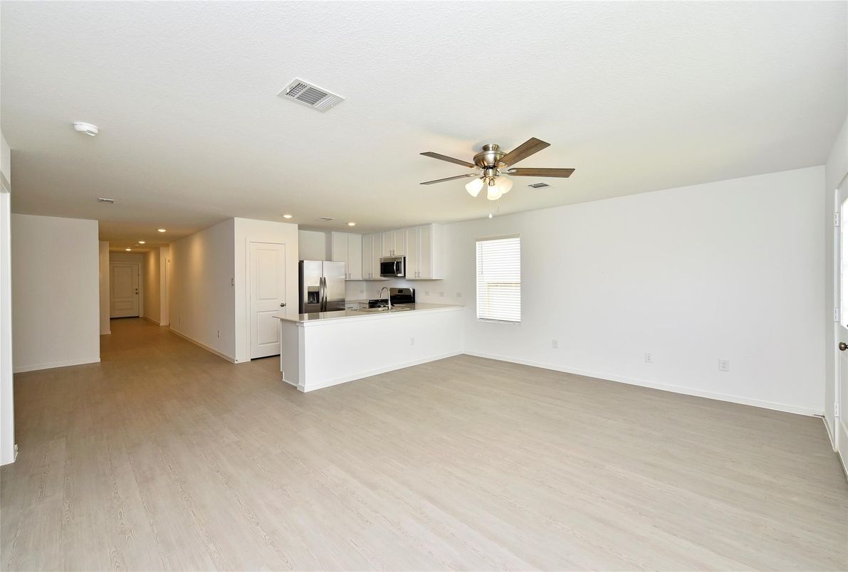 Empty room, Interior, Kitchen, Recessed Lighting, Stainless Steel Appliances, Wood Texture Flooring