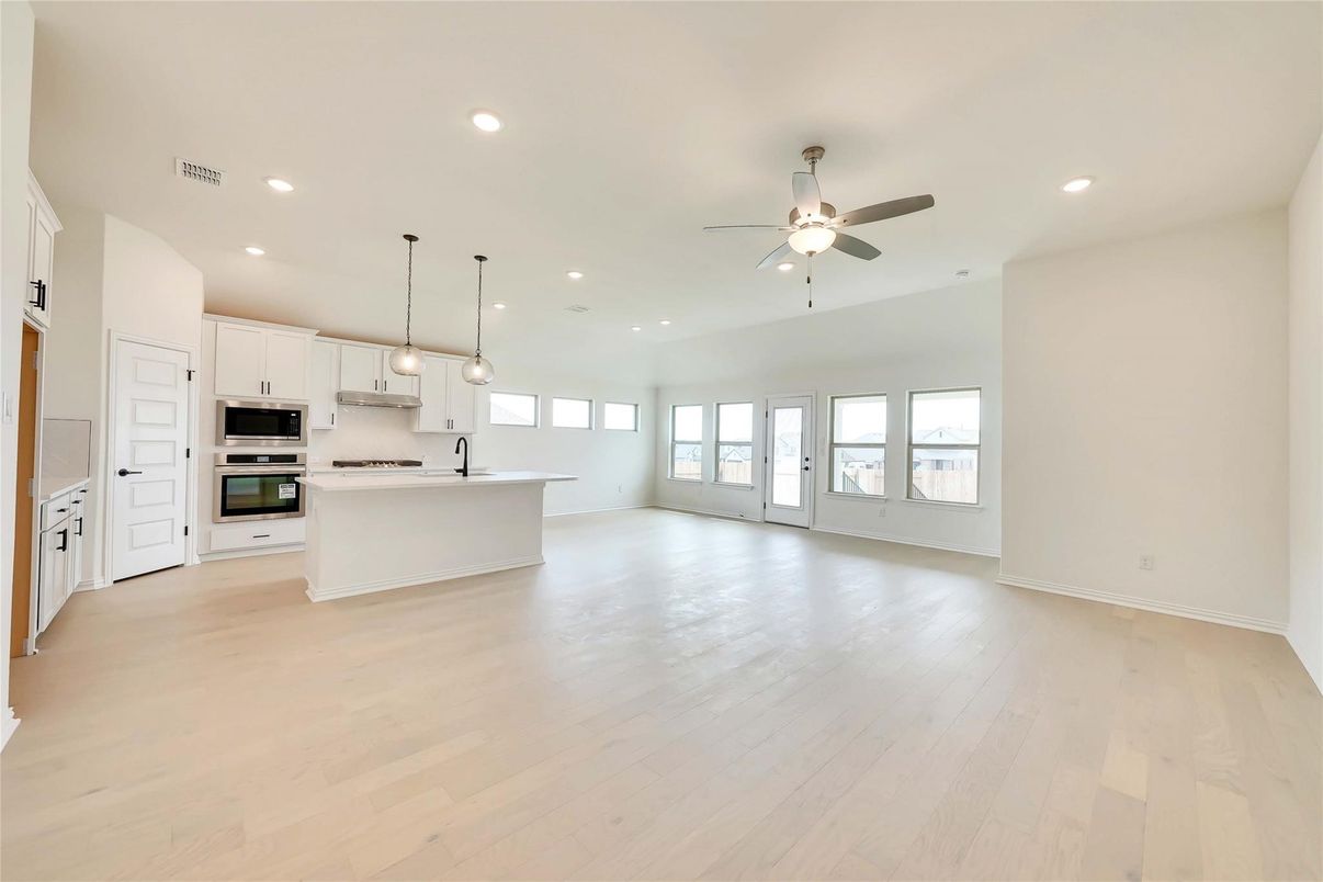 Empty room, Interior, Kitchen, Pendant Lights, Recessed Lighting, Stainless Steel Appliances, Wood Texture Flooring