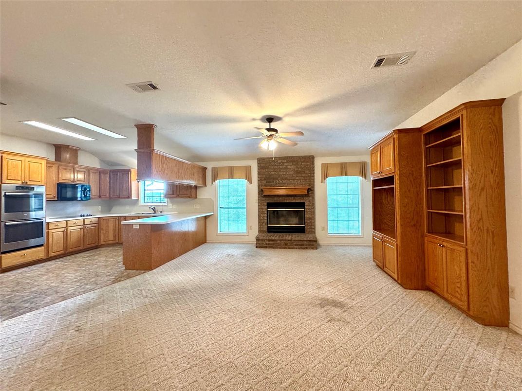 Empty room, Fireplace, Interior, Kitchen, Recessed Lighting, Stainless Steel Appliances, Stone Walls