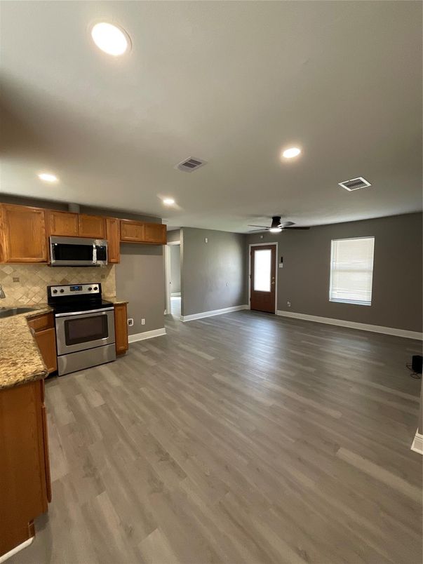 Empty room, Interior, Kitchen, Recessed Lighting, Stainless Steel Appliances, Wood Texture Flooring