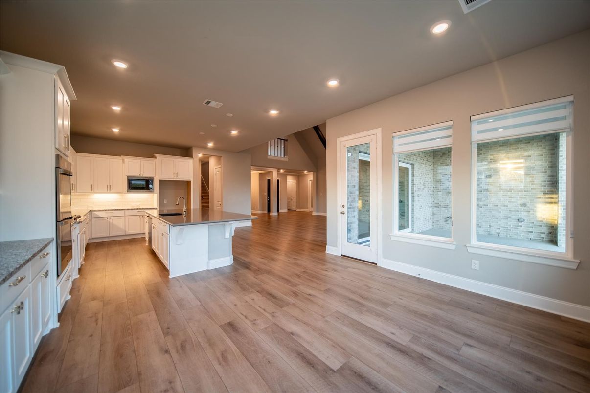 Empty room, Interior, Kitchen, Recessed Lighting, Stainless Steel Appliances, Wood Texture Flooring