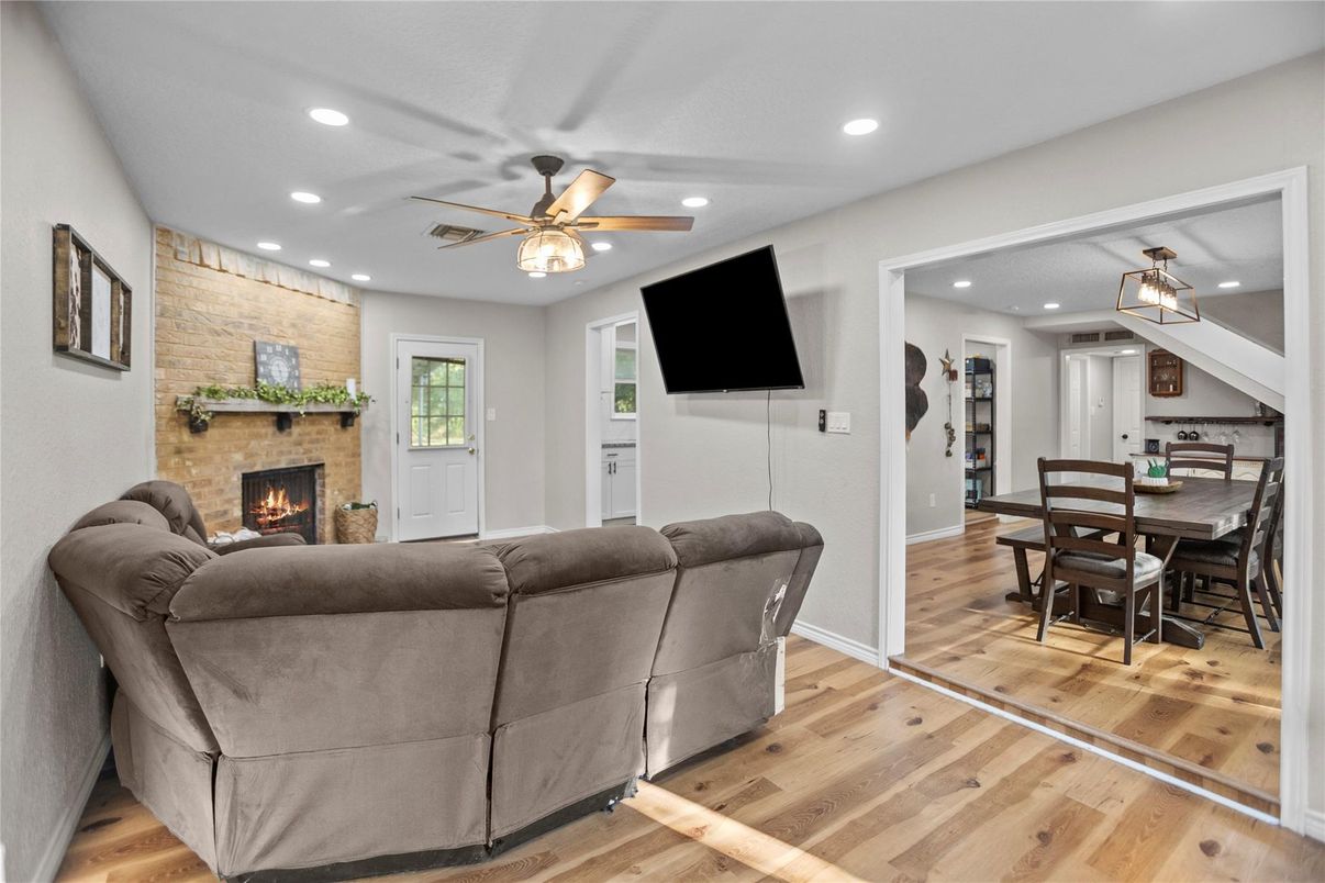Dining room, Fireplace, Interior, Living room, Recessed Lighting, Stone Walls, Wood Texture Flooring