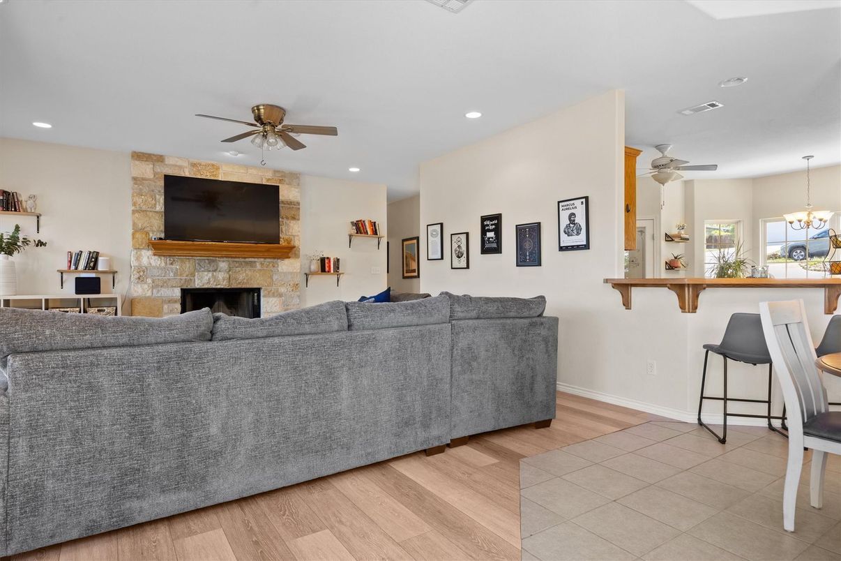 Chandelier, Fireplace, Interior, Living room, Recessed Lighting, Stone Walls, Wood Texture Flooring