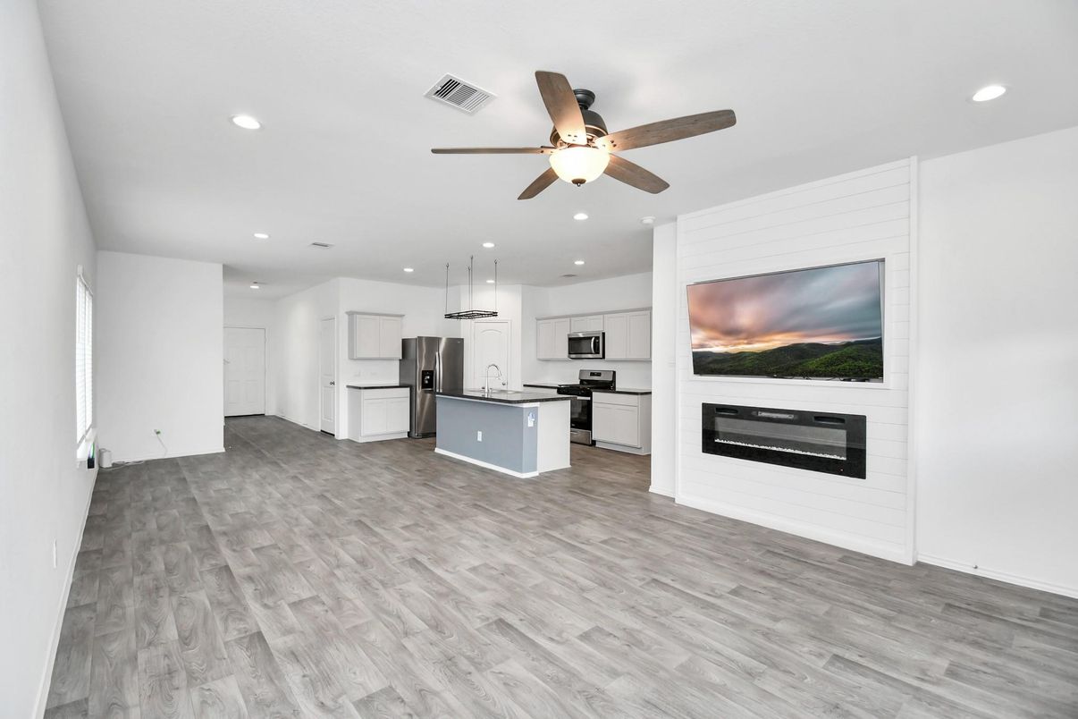 Empty room, Fireplace, Interior, Kitchen, Recessed Lighting, Stainless Steel Appliances, Wood Texture Flooring