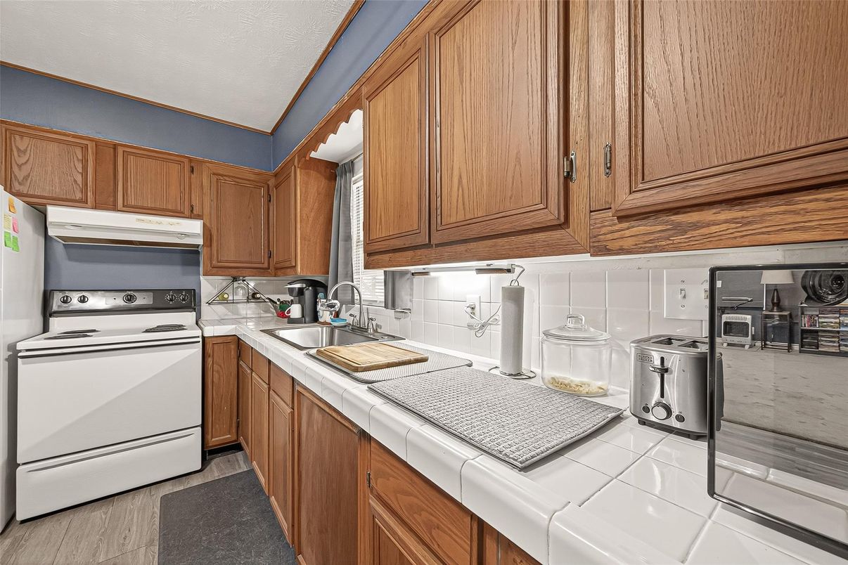 Interior, Kitchen, Tile Countertops, Washer, Wood Texture Flooring