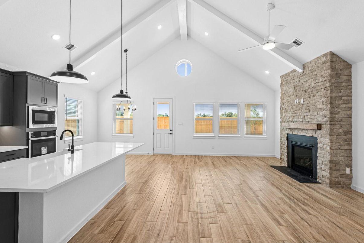 Empty room, Fireplace, Interior, Kitchen, Pendant Lights, Recessed Lighting, Stainless Steel Appliances, Stone Walls, Wood Texture Flooring