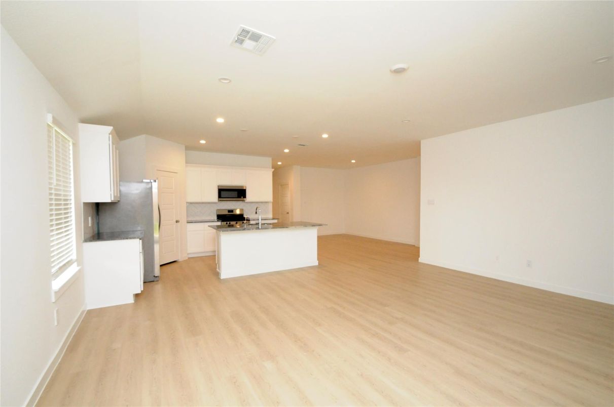Empty room, Interior, Kitchen, Recessed Lighting, Stainless Steel Appliances, Wood Texture Flooring