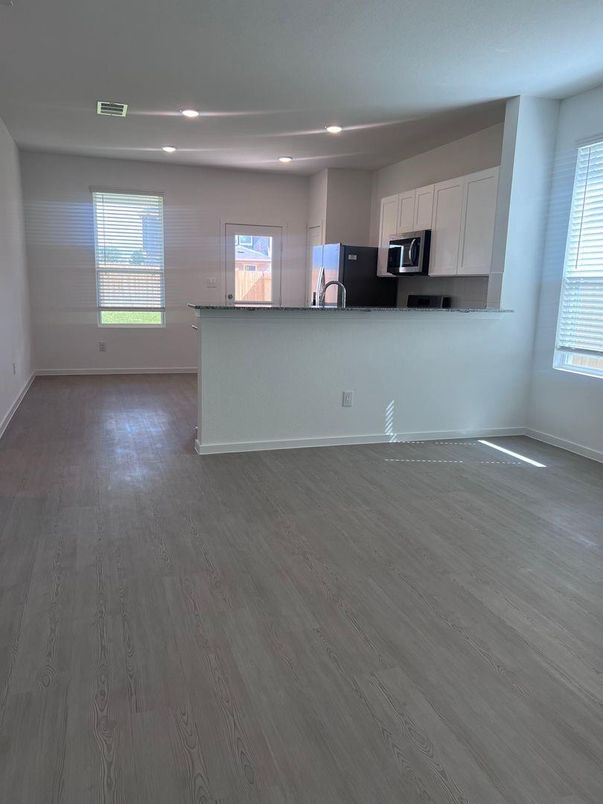 Empty room, Interior, Kitchen, Recessed Lighting, Stainless Steel Appliances, Wood Texture Flooring