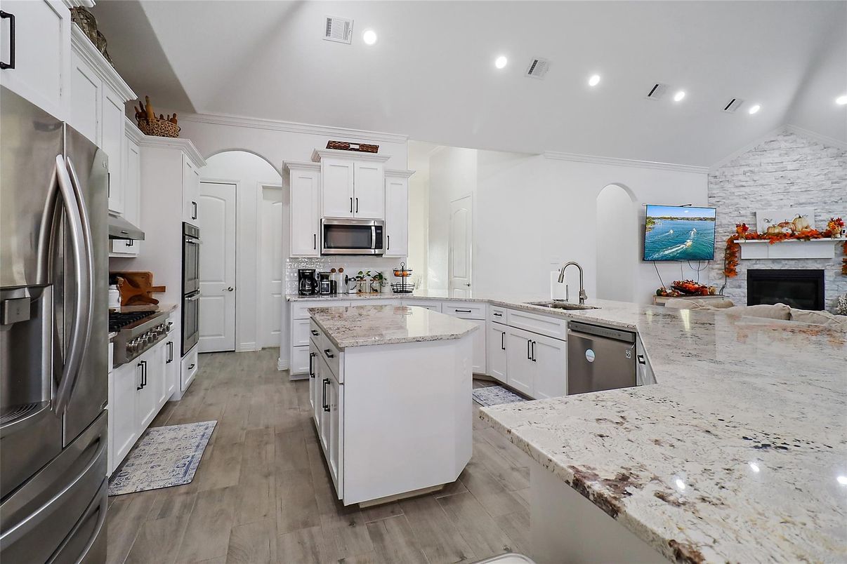 Fireplace, Interior, Kitchen, Recessed Lighting, Stainless Steel Appliances, Stone Walls, Wood Texture Flooring