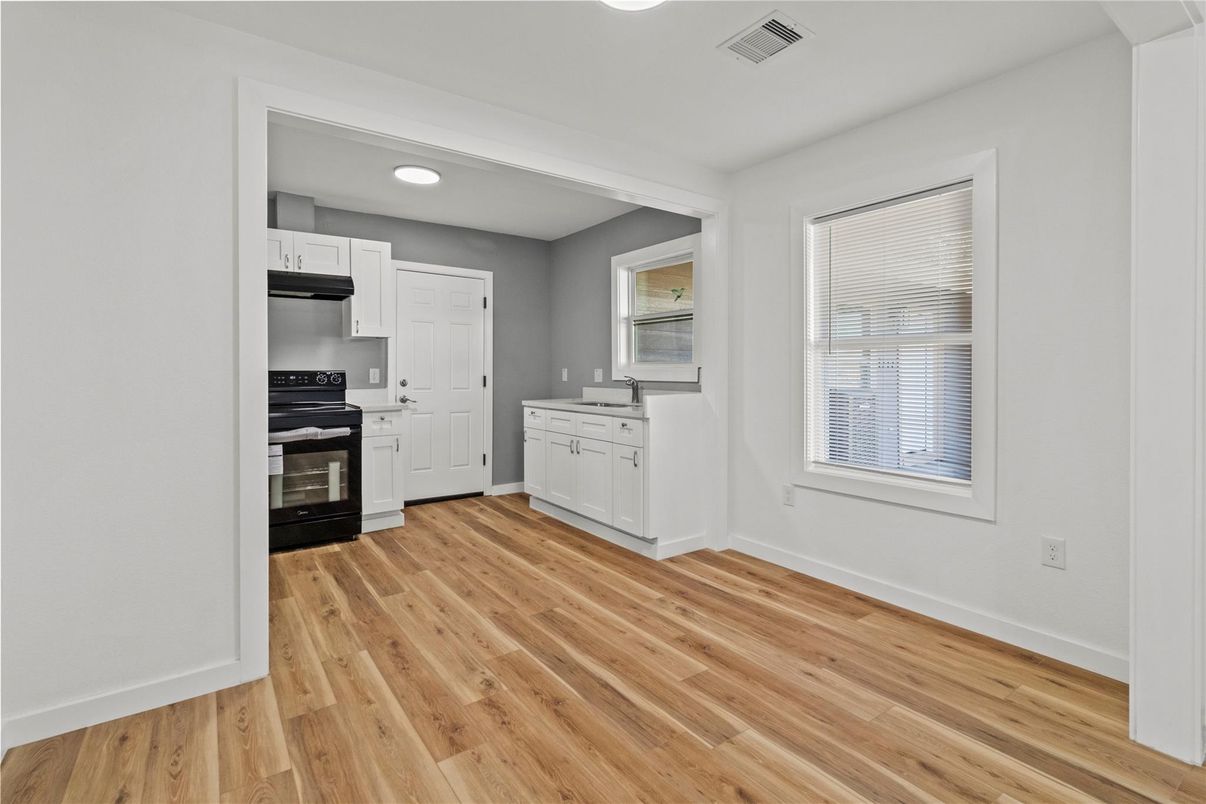 Empty room, Interior, Kitchen, Recessed Lighting, Stainless Steel Appliances, Wood Texture Flooring