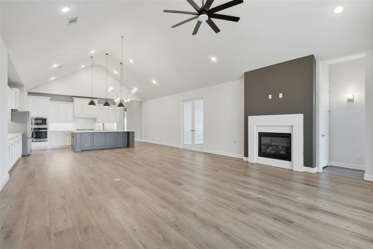 Empty room, Fireplace, Interior, Kitchen, Pendant Lights, Recessed Lighting, Stainless Steel Appliances, Wood Texture Flooring
