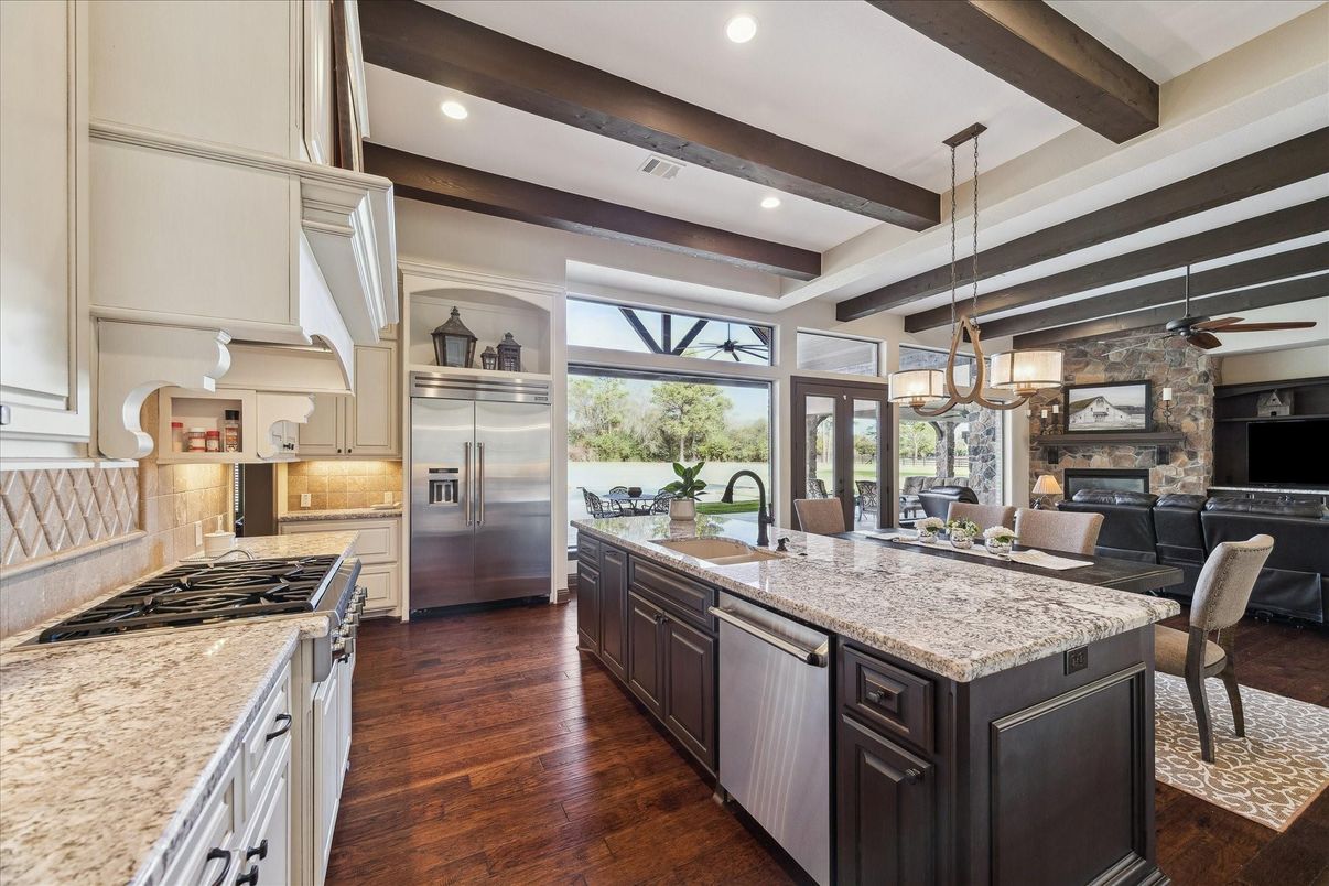 Chandelier, Dining room, Fireplace, Interior, Kitchen, Pendant Lights, Recessed Lighting, Stainless Steel Appliances, Stone Walls, Wooden Beams, Wood Texture Flooring