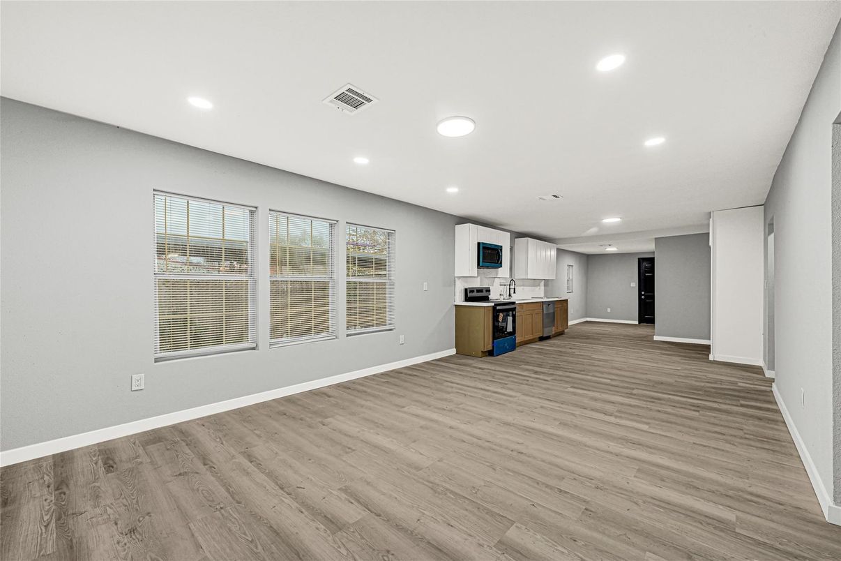 Empty room, Interior, Kitchen, Recessed Lighting, Stainless Steel Appliances, Wood Texture Flooring