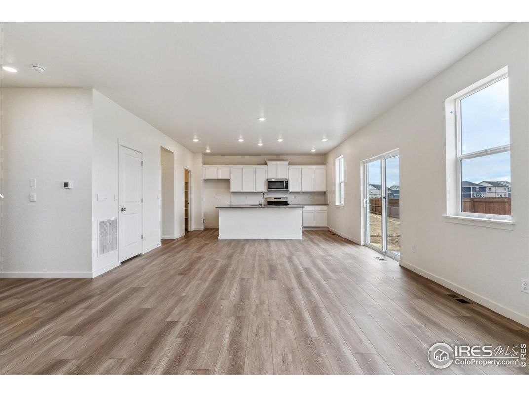 Empty room, Interior, Kitchen, Recessed Lighting, Stainless Steel Appliances, Wood Texture Flooring