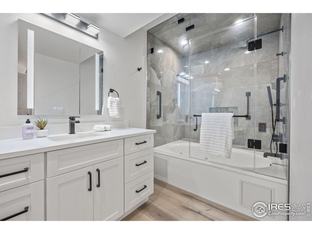 Bathroom, Dual Sink Vanities, Glass Shower, Interior, Marble Walls, Recessed Lighting, Wood Texture Flooring