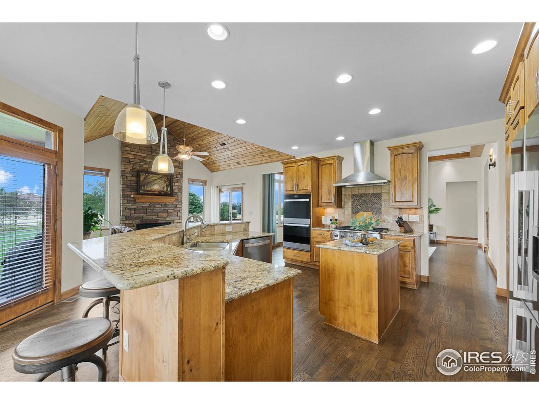 Fireplace, Interior, Kitchen, Pendant Lights, Recessed Lighting, Stainless Steel Appliances, Stone Walls, Wood Texture Flooring