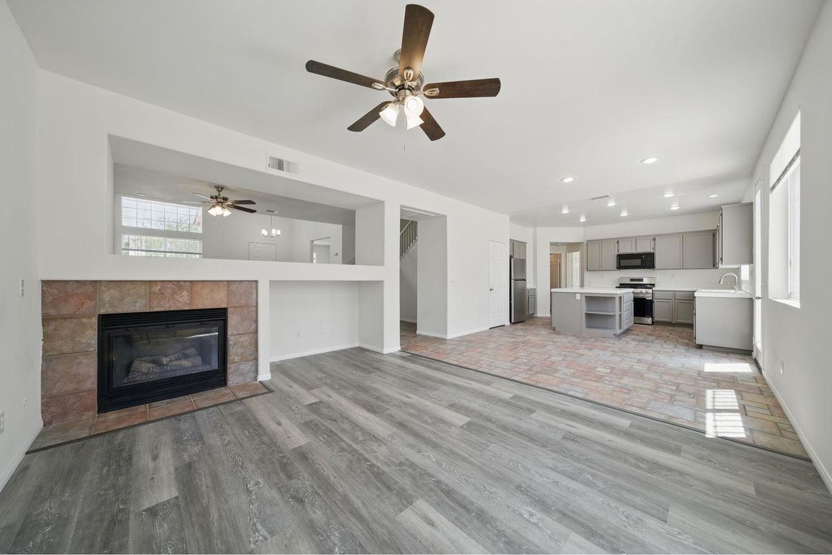 Empty room, Fireplace, Interior, Kitchen, Recessed Lighting, Stainless Steel Appliances, Wood Texture Flooring