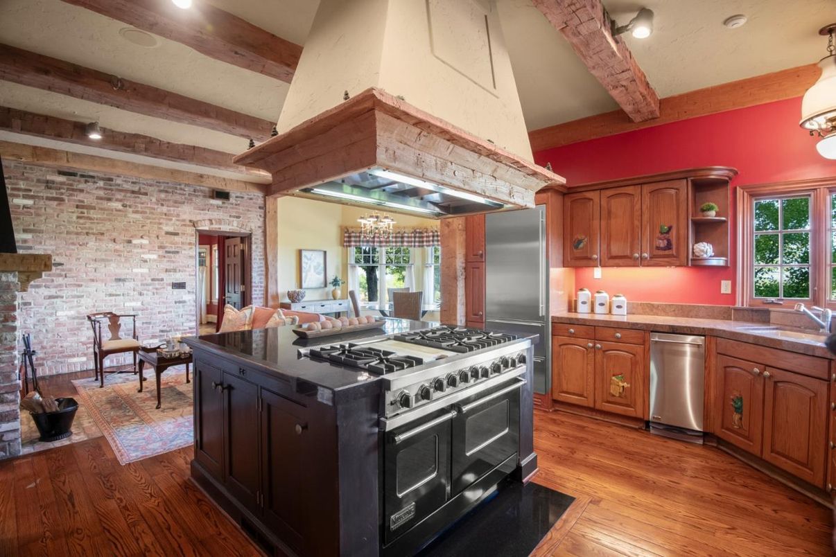Chandelier, Dining room, Interior, Kitchen, Pendant Lights, Recessed Lighting, Stainless Steel Appliances, Stone Walls, Wooden Beams, Wood Texture Flooring